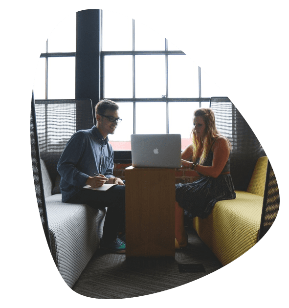 Salesforce consultant woman explaining a solution on laptop to a colleague taking notes